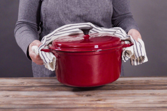 A women holding a hot dutch oven.