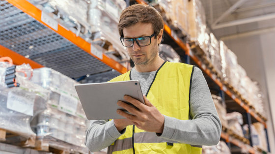 Man in uniform looking at a pad for warehouse management