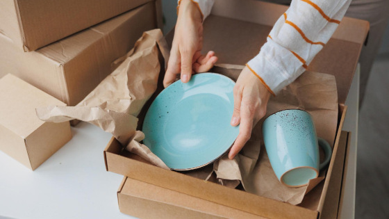 Woman packing ceramic plates carefully