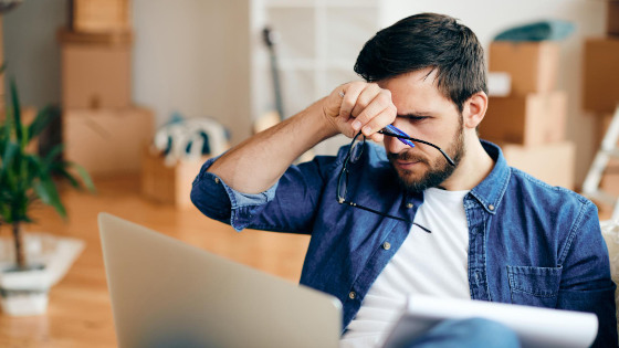 A Distraught man looking at laptop