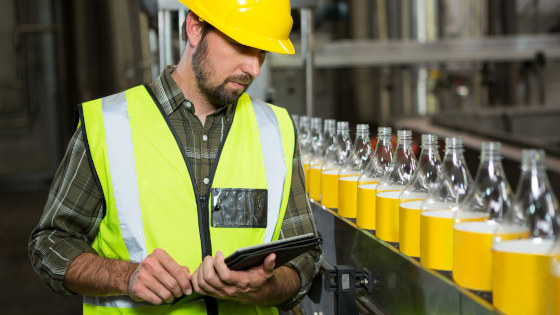 Male worker using digital tablet in factory