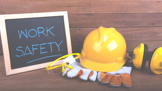 A board writing "WORK SAFETY" on it, with safety helment and safety ear puffs on side