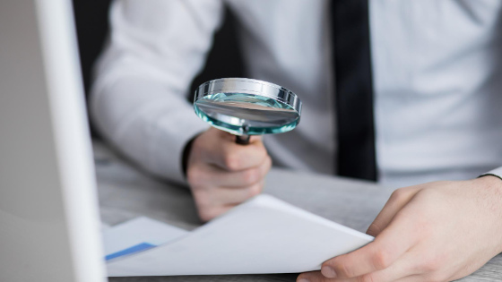 A man checking document with a magnifier