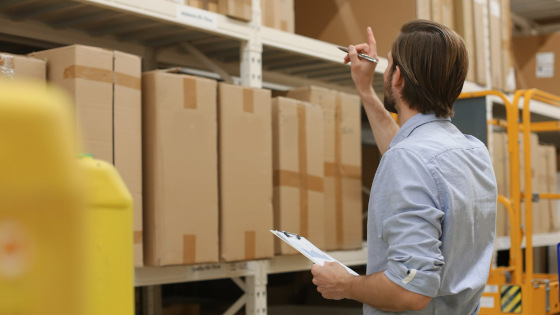 Man checking carton quantity in a warehouse